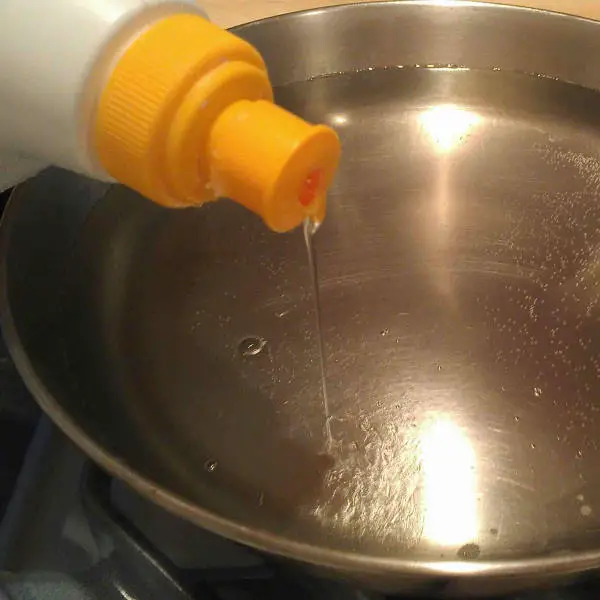 adding dish soap to pan