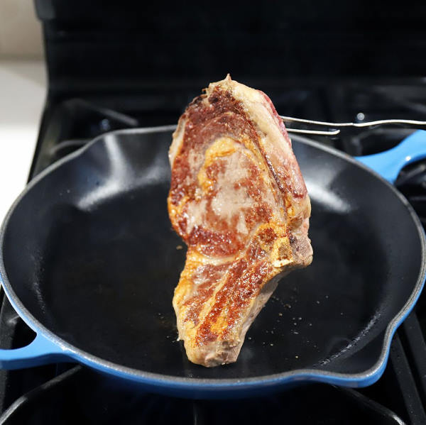 cooking steak in enameled skillet