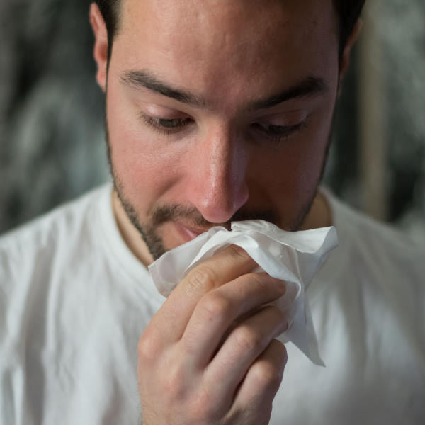 man wiping nose