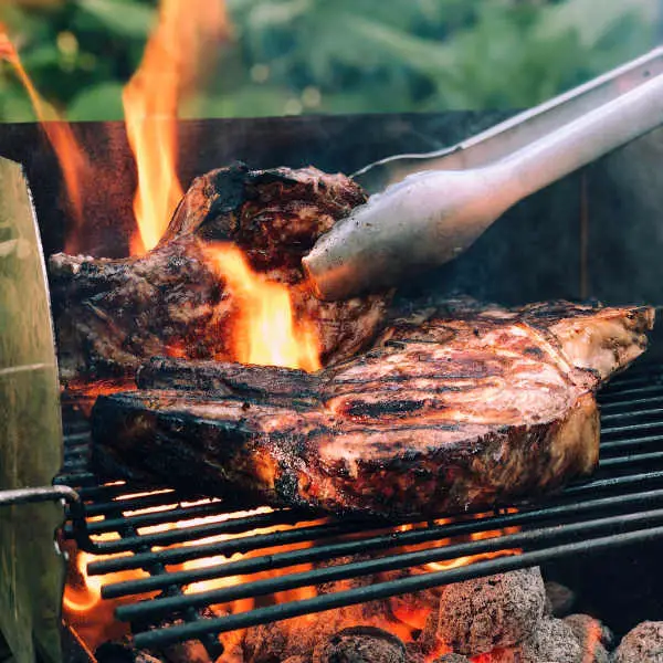 searing steaks on charcoal grill