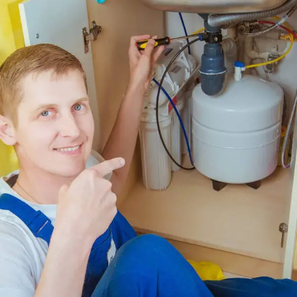 man installing under sink water filter