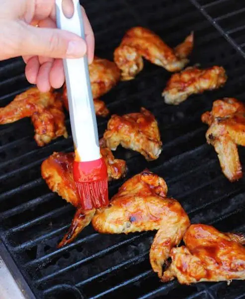 adding sauce to BBQ chicken