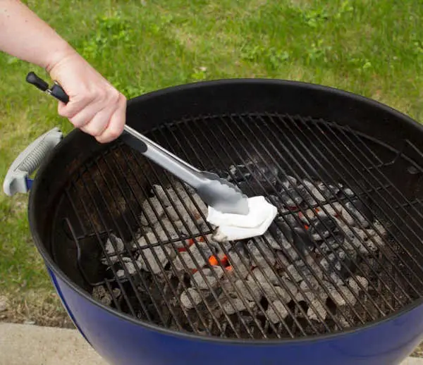 cleaning charcoal grill grate with towel