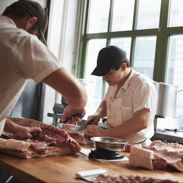 butchers cutting raw meat
