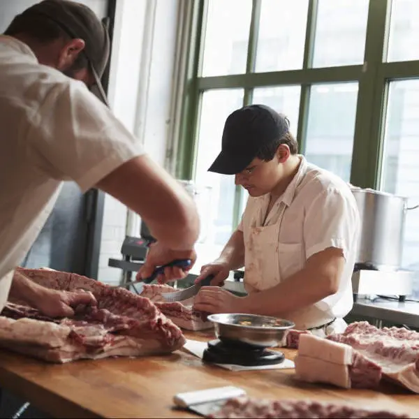 butchers cutting raw meat