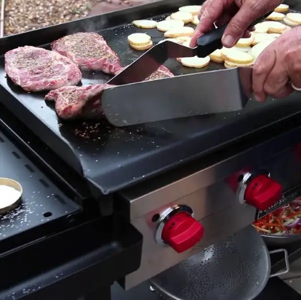 cooking steaks and potatoes on griddle