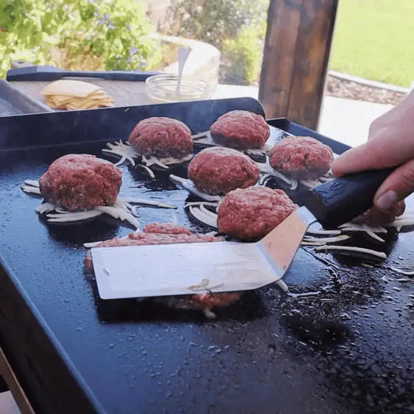 making smash burgers on griddle